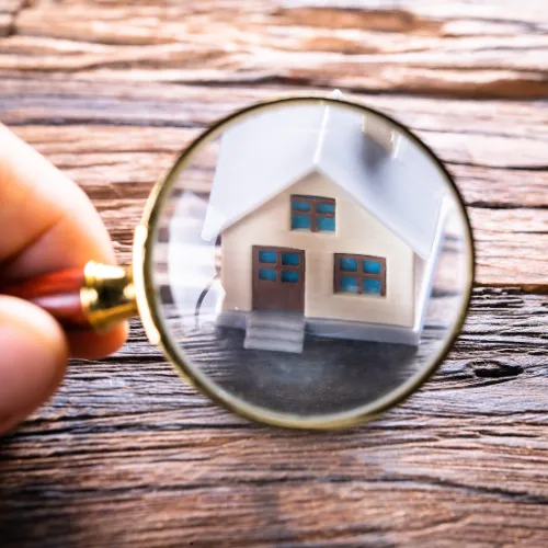 Picture of a magnified glass over a home on a table