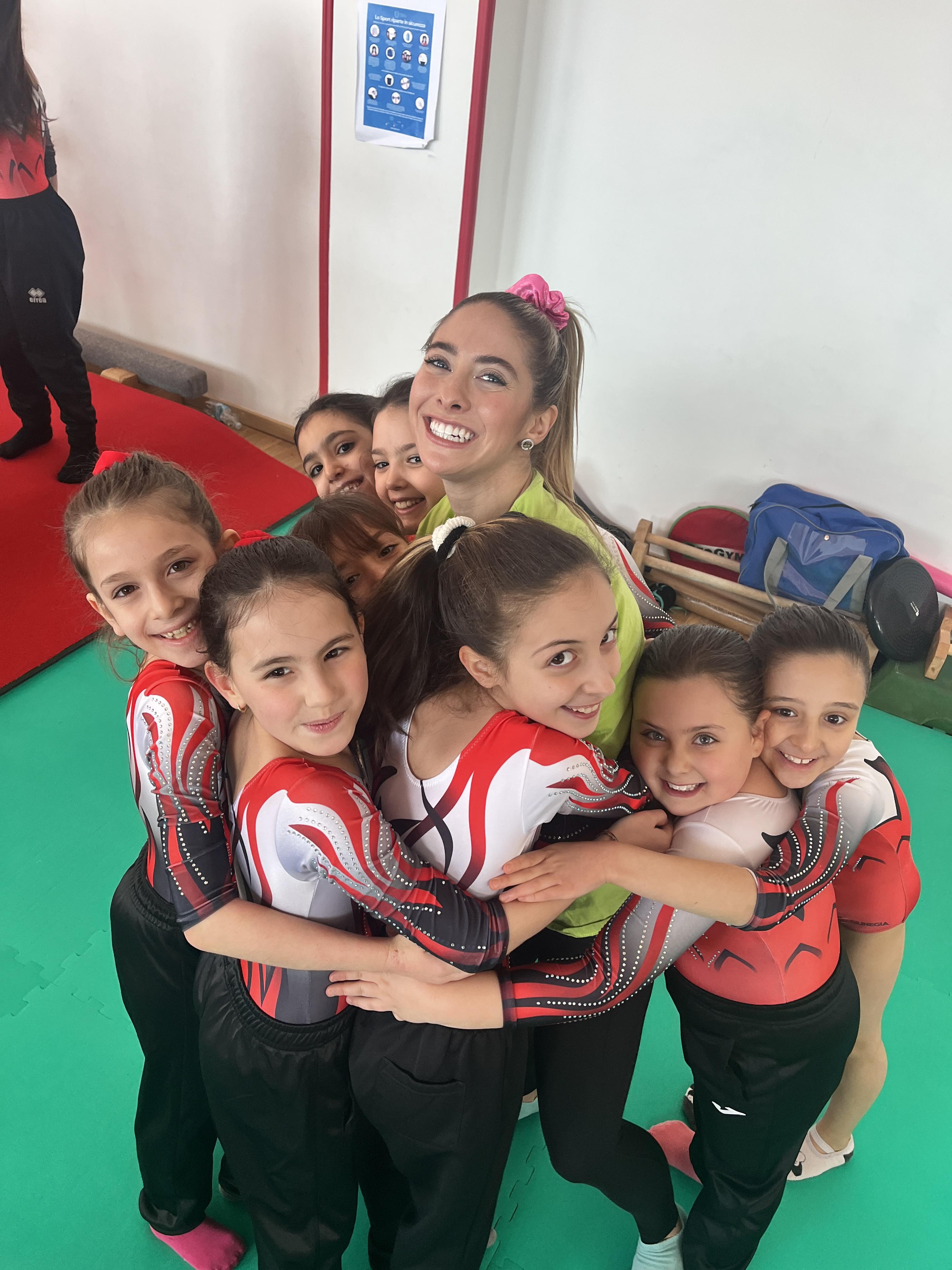 Sophia Campana smiling and coaching a young gymnast
