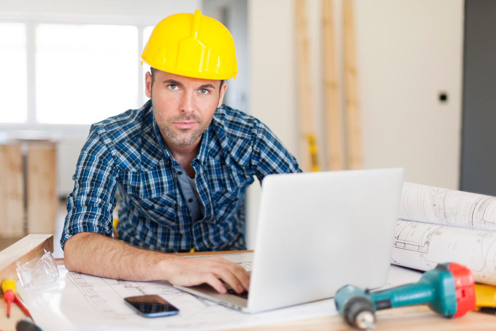 exterior contractor man sitting with laptop