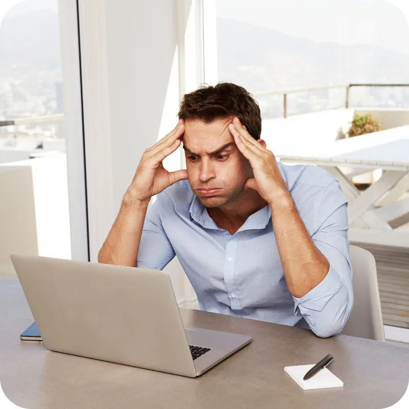 Man looking stressed while working on a laptop