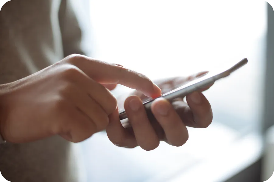 Person using a smartphone, representing phone number ownership.