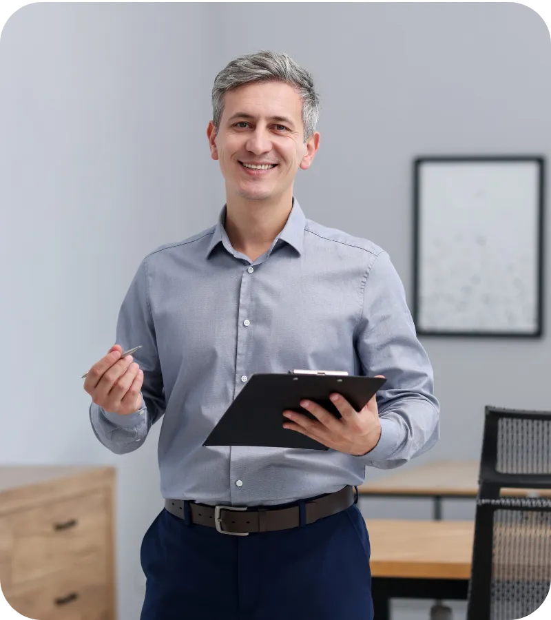 Man holding a clipboard and smiling.
