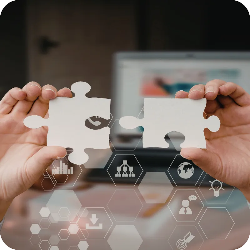 Hands holding two puzzle pieces being joined together.