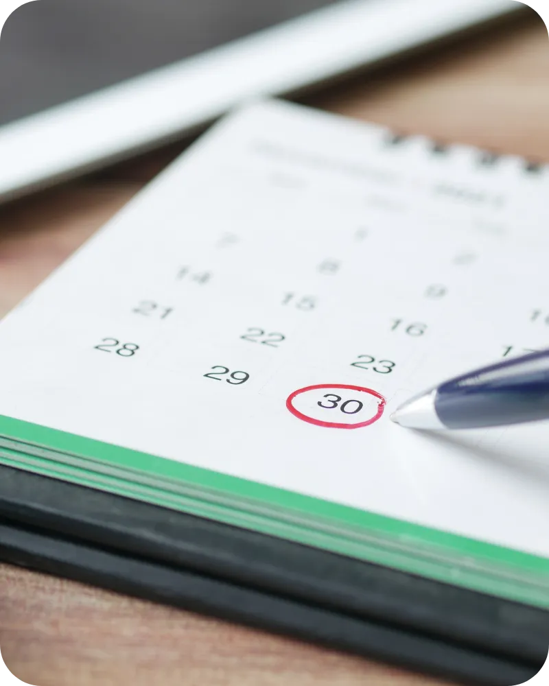 Calendar with a date circled and a pen resting on the page.