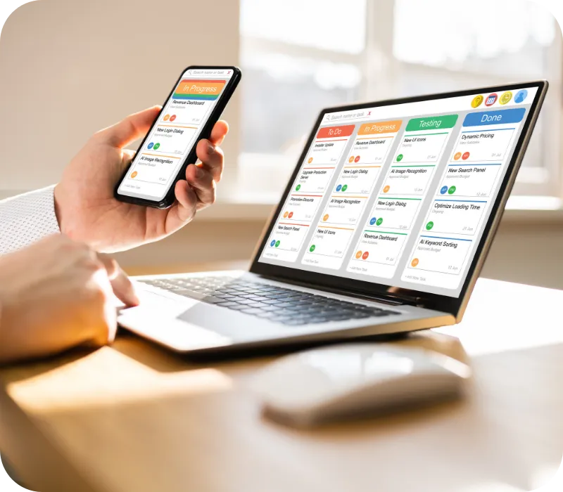 Smartphone and laptop displaying a scheduling dashboard.