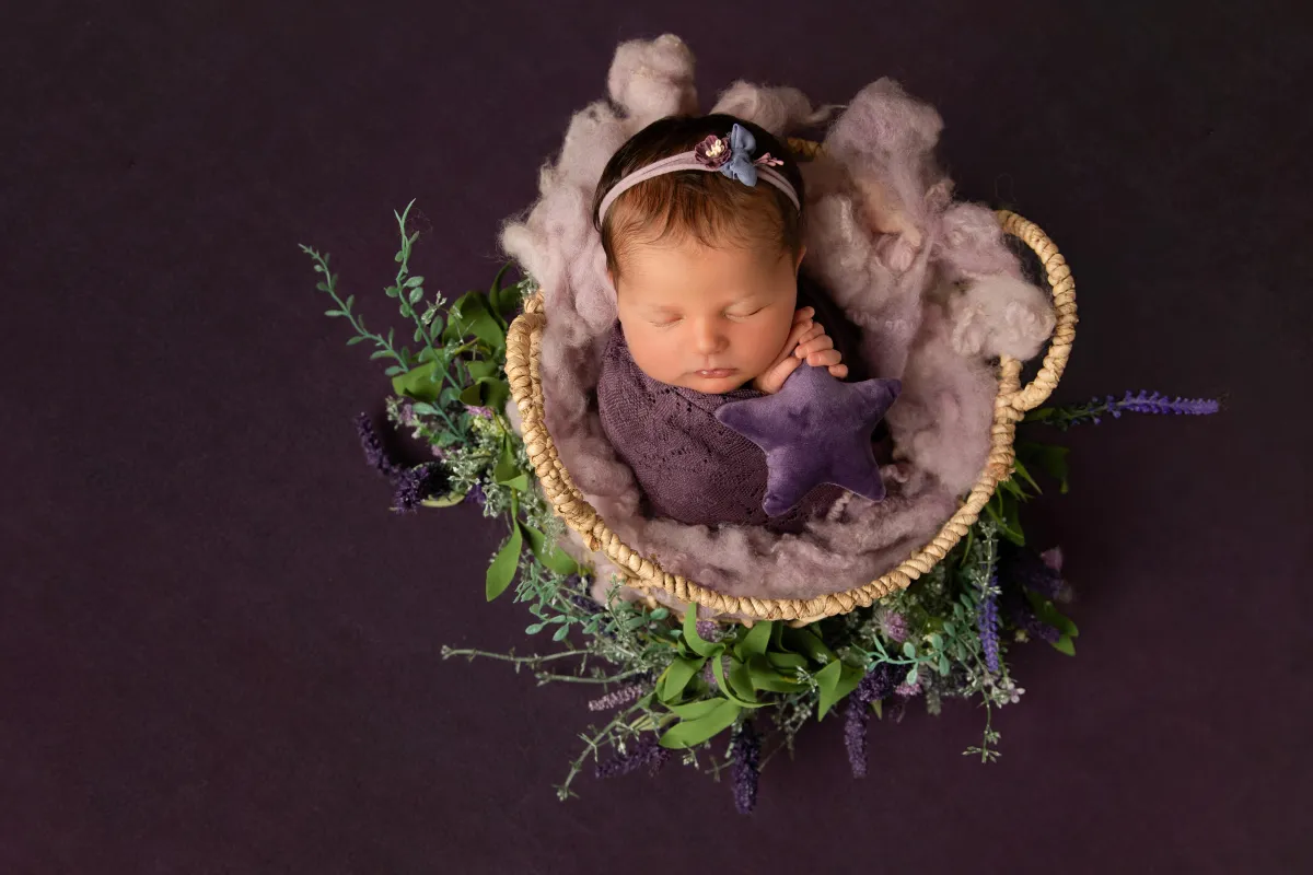 New parents holding their sleeping newborn during a calm studio session