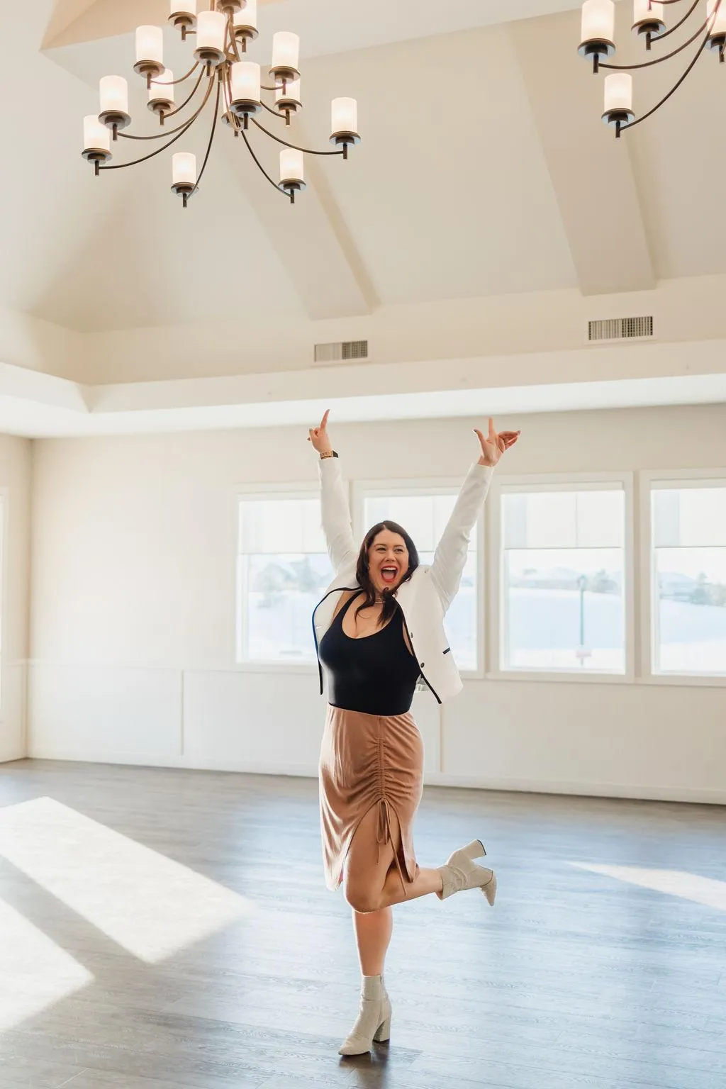 four people all on laptops, two men and two women, listen to person talking in a board meeting