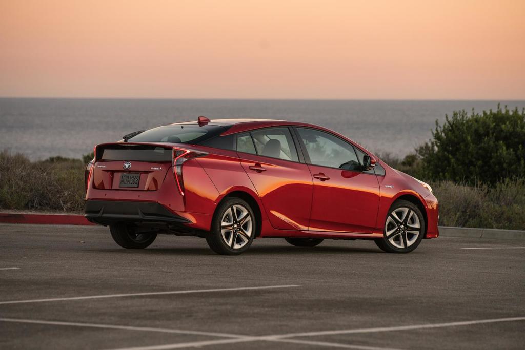 a man standing next to a white car near the ocean