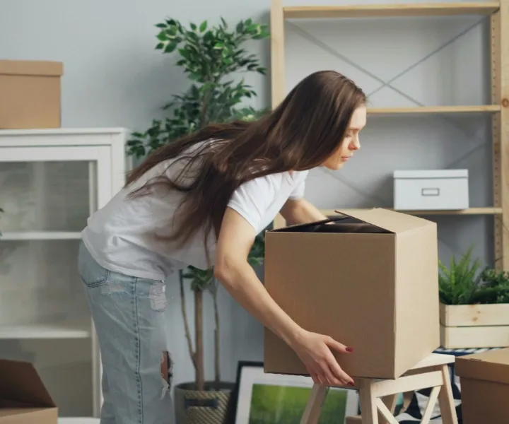 A professional cleaner from Maryland Spotless Maid Service carefully organizing moving boxes during a move-in and move-out cleaning service appointment in Bethesda.