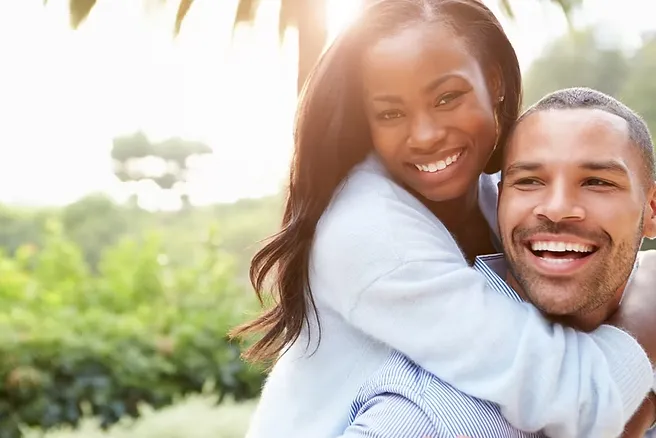 Woman hugging man from behind and both smiling