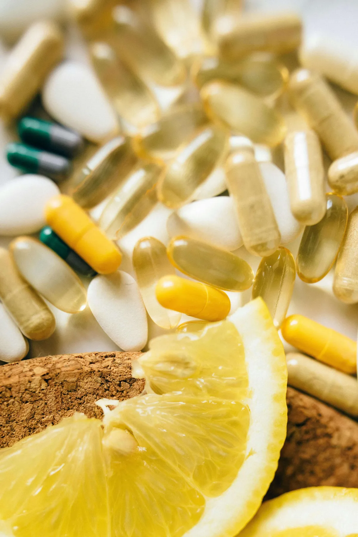 Verschillende voedingssupplementen en een schijfje citroen, als visuele representatie van micronutriënten zoals vitaminen en mineralen