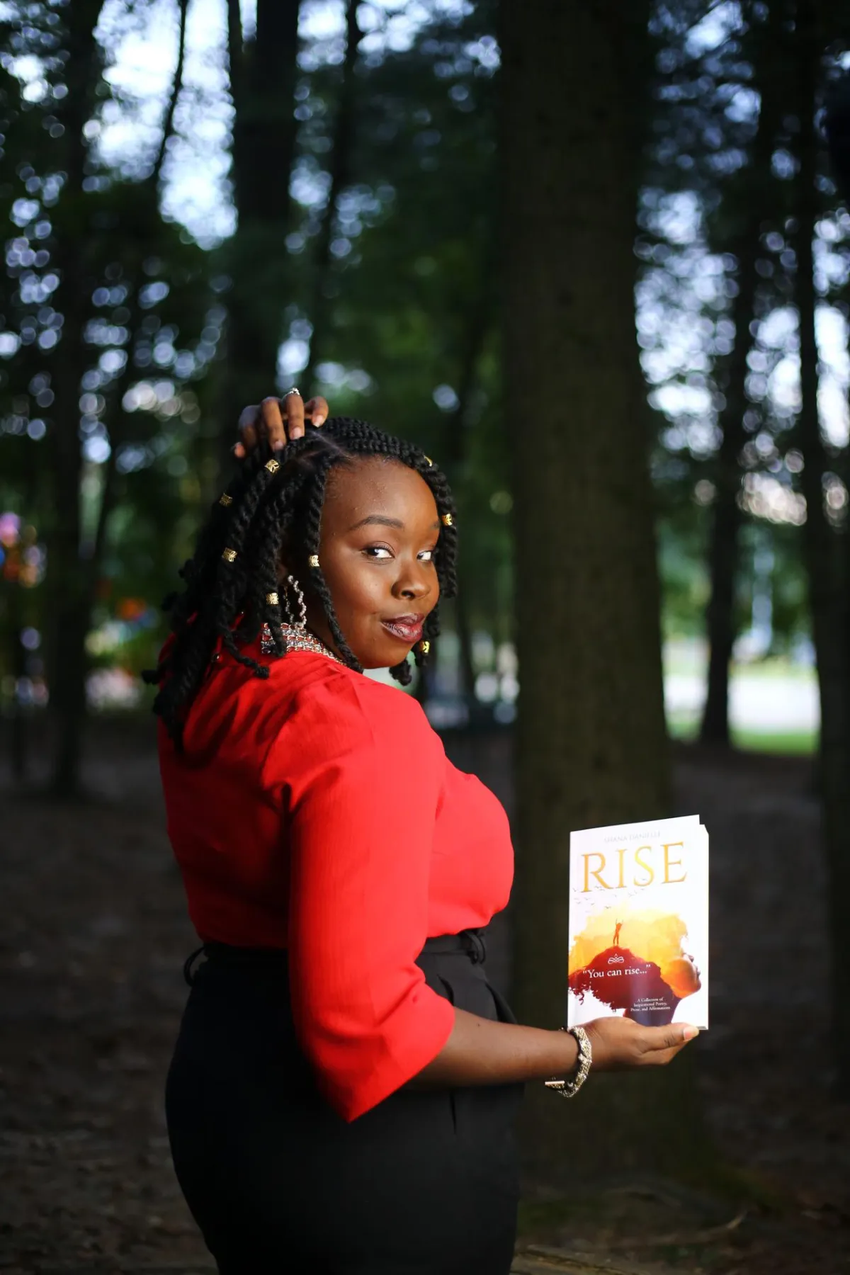 Shana Danielle holding Rise Poetry Book