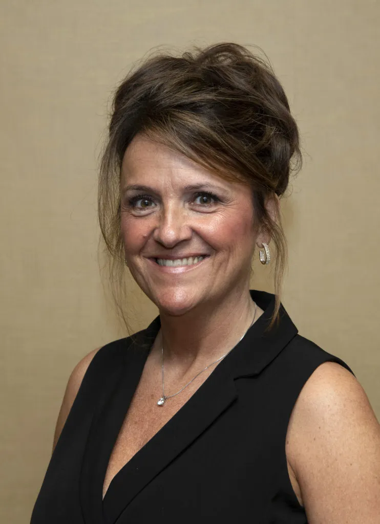 Portrait photo of a smiling woman in a black sleeveless top.