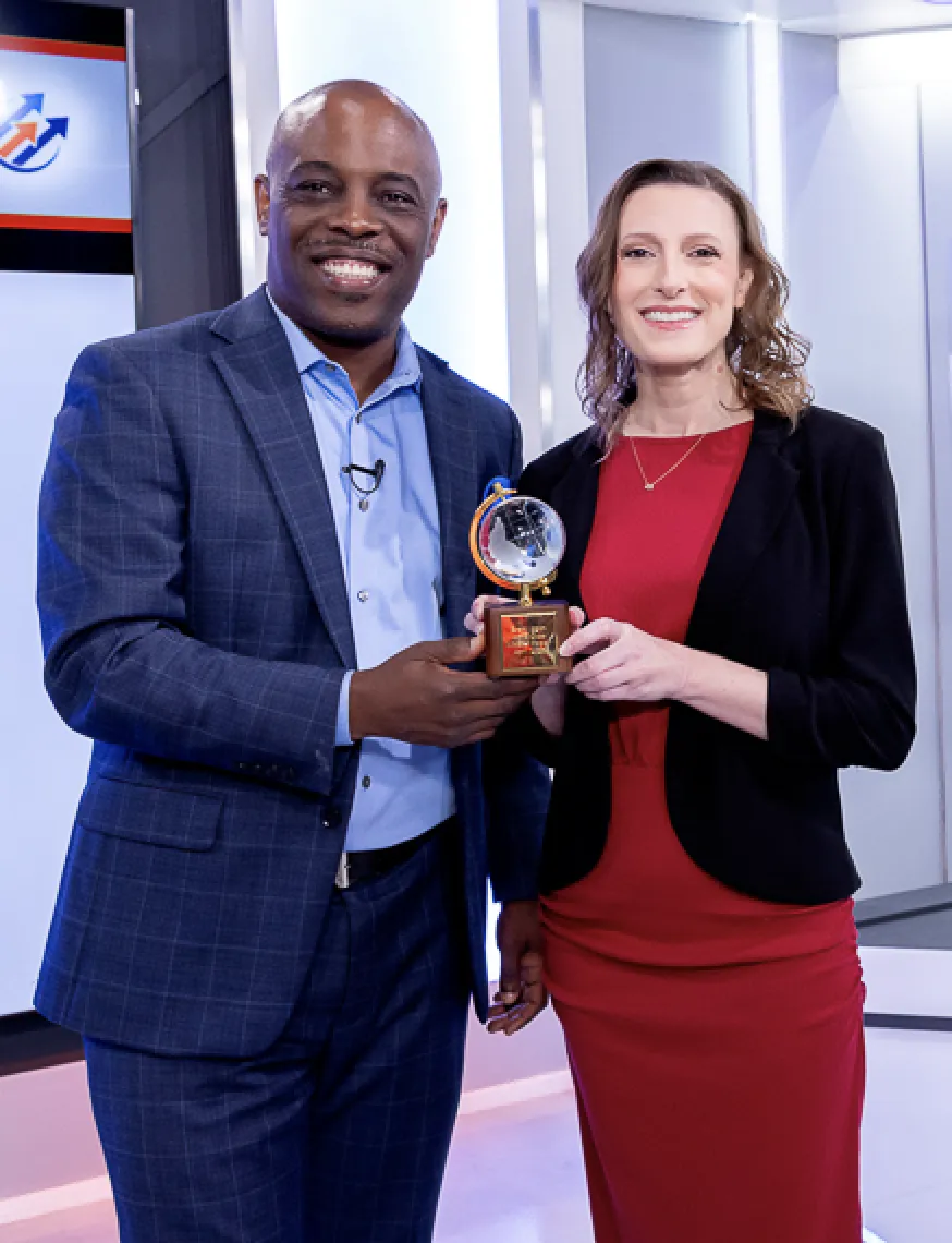 Jennifer Licciardi standing beside a man as she receives a reward.