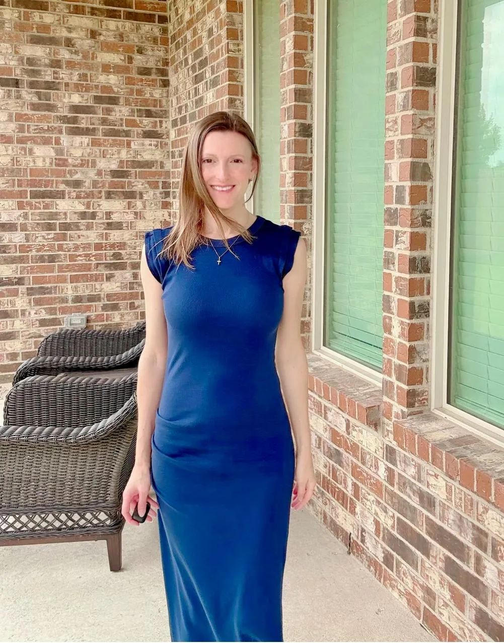 Jennifer Licciardi standing outside a brick building, wearing a blue dress.