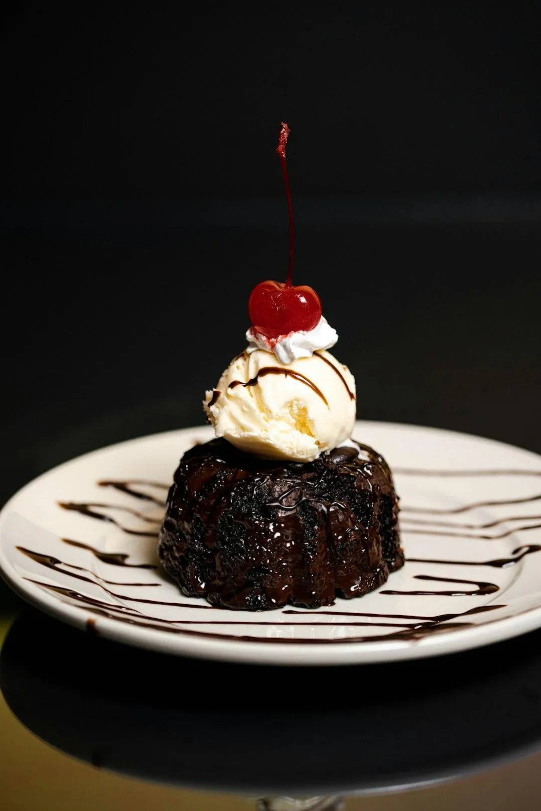 chocolate lava cake with vanilla ice cream, whip cream, and a cherry on top
