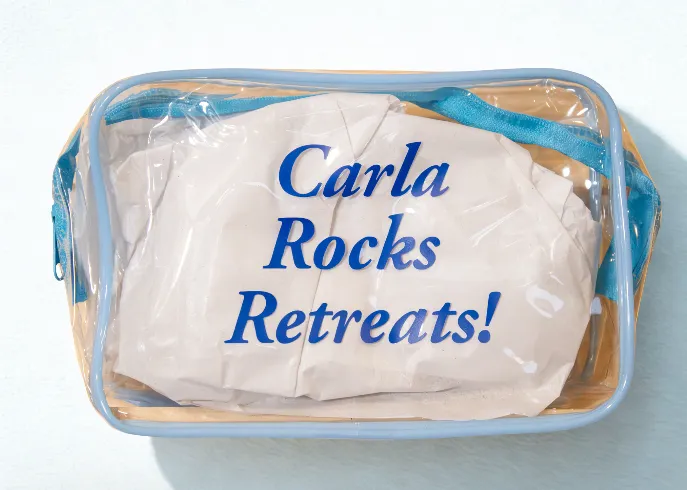 Clear plastic travel pouch with 'Carla Rocks Retreats!' written in blue