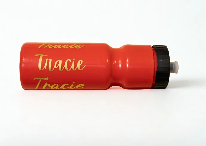 Orange plastic water bottle with 'Tracie' written in gold lettering