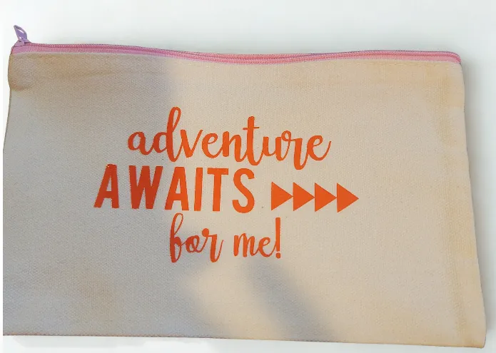 Canvas pouch with 'adventure AWAITS for me!' in orange lettering