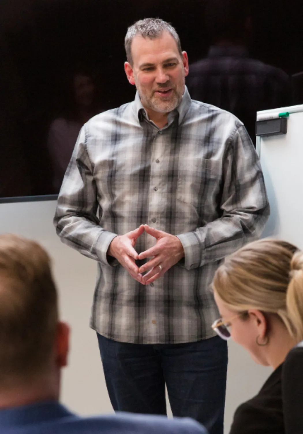 Workplace chaplain Garth Epp speaking with a small group beside a flip chart.