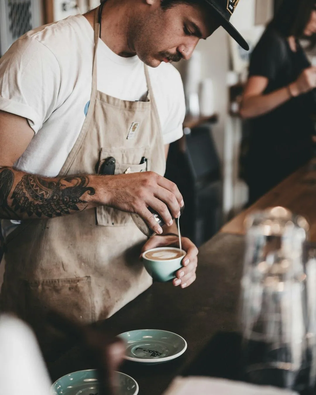 Ein Barkeeper bereitet eine Tasse leckeren Rahm Roast Kaffee vor