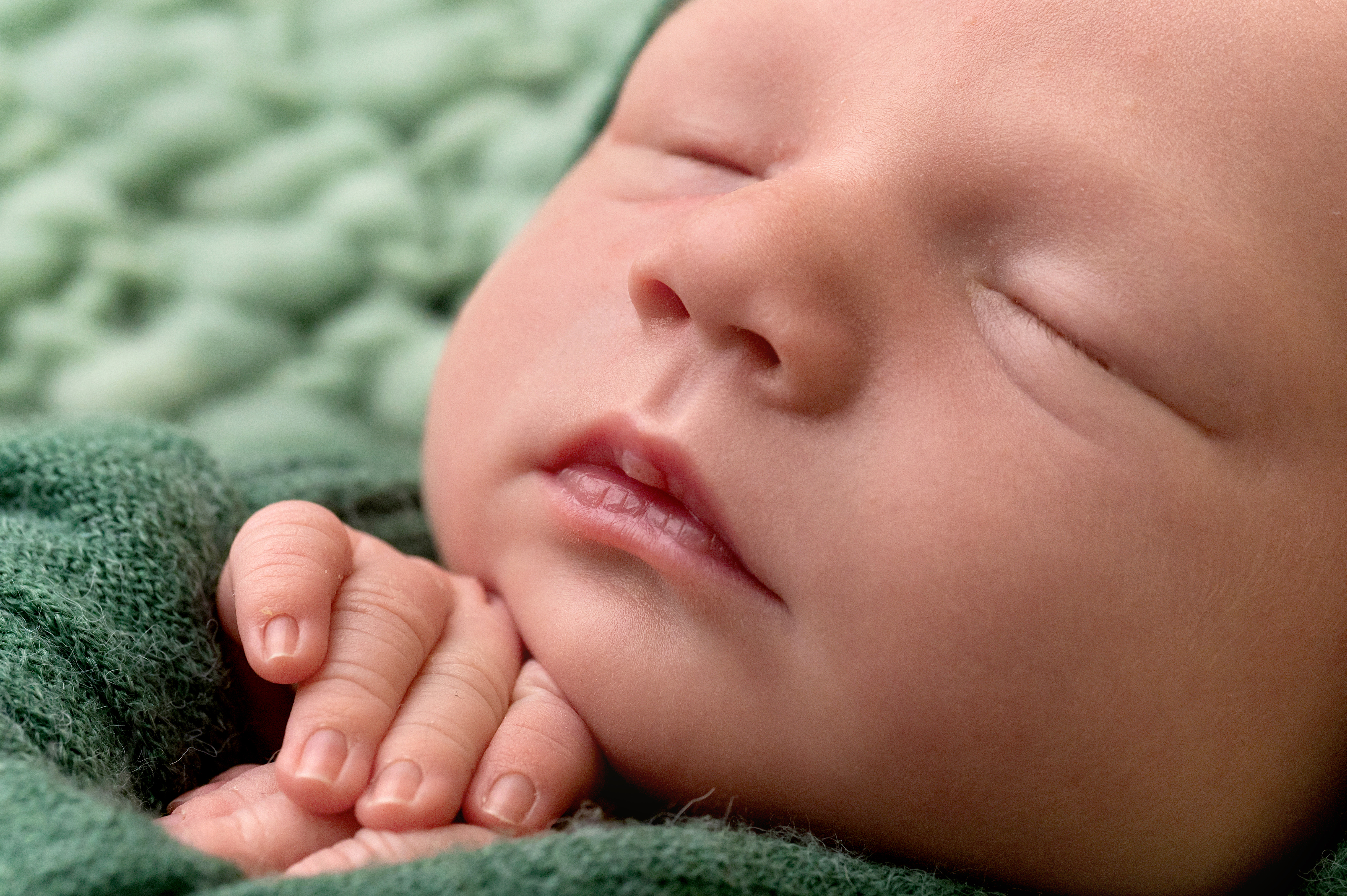 Parent holding tiny newborn feet at Yellow Blossom Photography