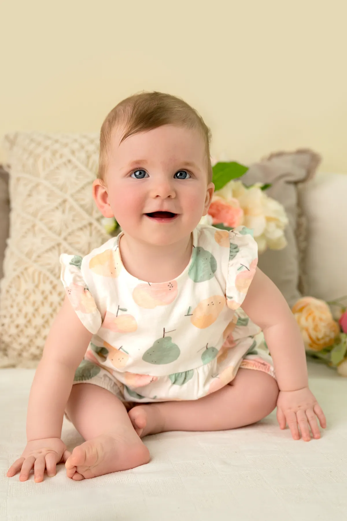 Joyful one-year-old baby tasting birthday cake during a bright, natural light cake smash studio photoshoot
