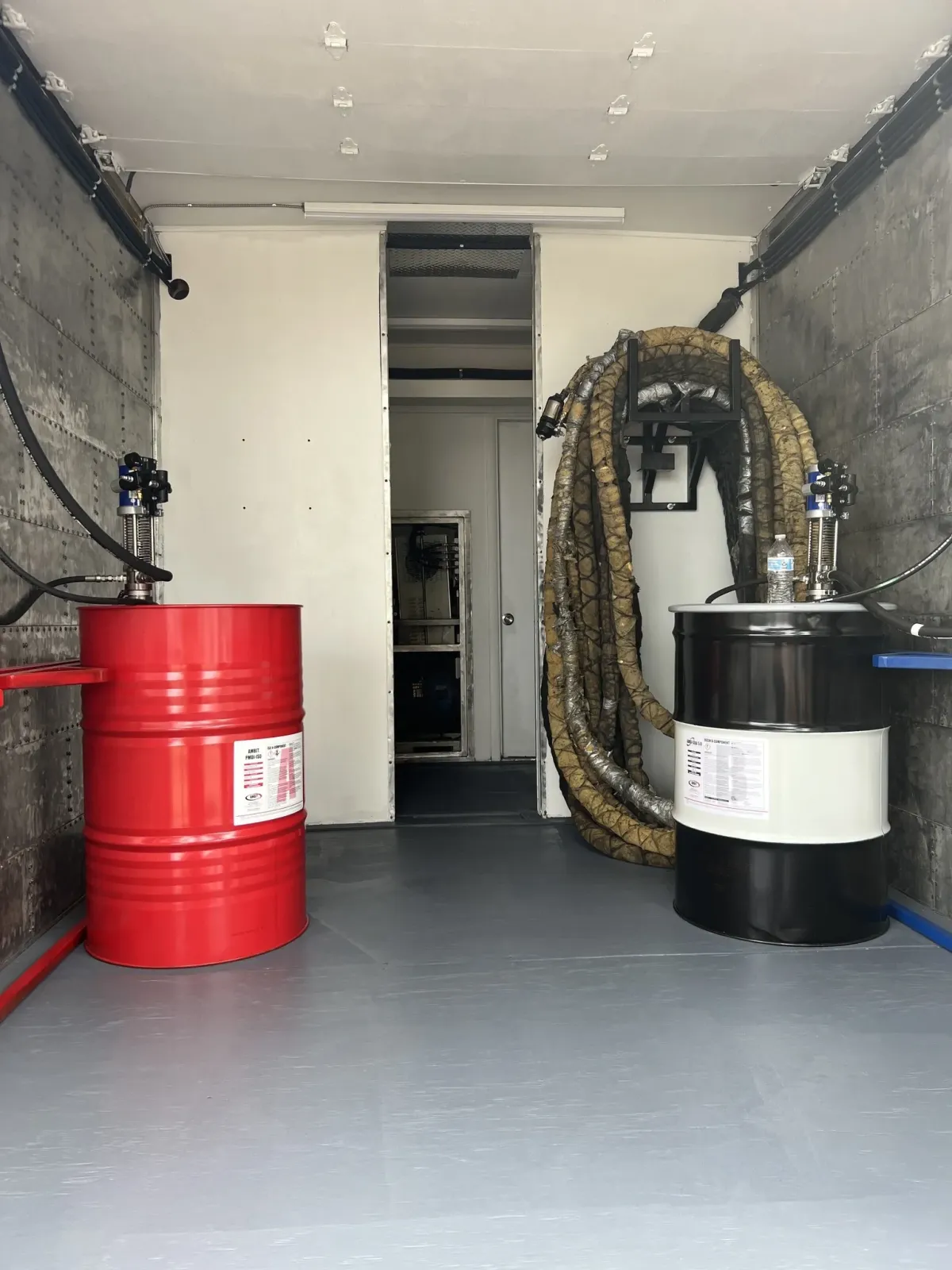 Refurbished spray foam rig with chemical drums and hose setup by Spray Tech Services in Panama City, FL
