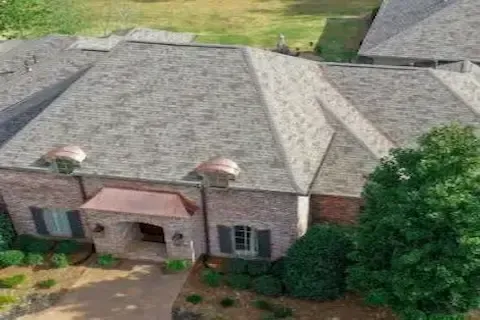 Aerial view of completed architectural shingle roof on large brick estate by Maple Grove Roofing Co.