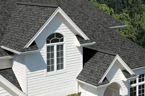 Dark charcoal asphalt shingles on white residential home following full roof replacement in Maple Grove