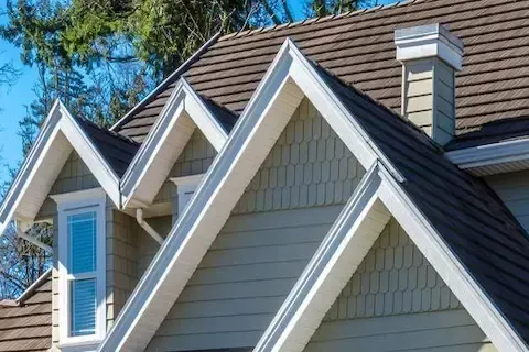 Triple gable peaks with brown architectural shingles and fresh white fascia trim on Maple Grove home