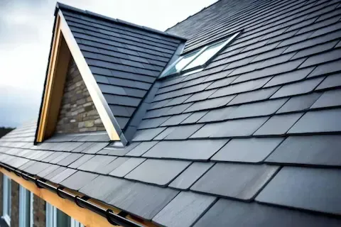 Slate-style roofing tiles with dormer and skylight on newly completed residential roof installation