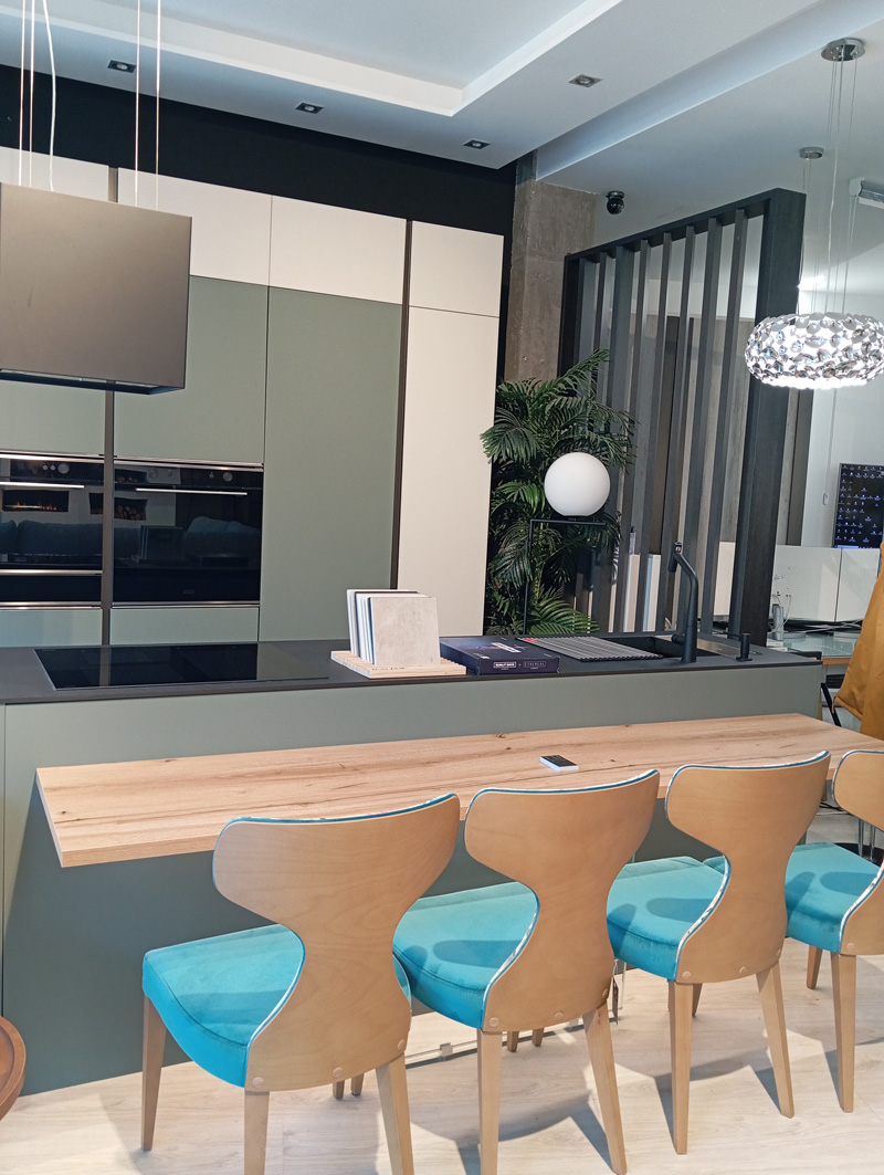 Terraza exterior con zona de comedor, césped cuidado, plantas autóctonas y vistas despejadas a la montaña, ideal para reuniones familiares y momentos de relax al aire libre.