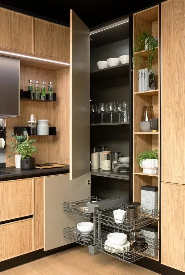 Terraza exterior con zona de comedor, césped cuidado, plantas autóctonas y vistas despejadas a la montaña, ideal para reuniones familiares y momentos de relax al aire libre.