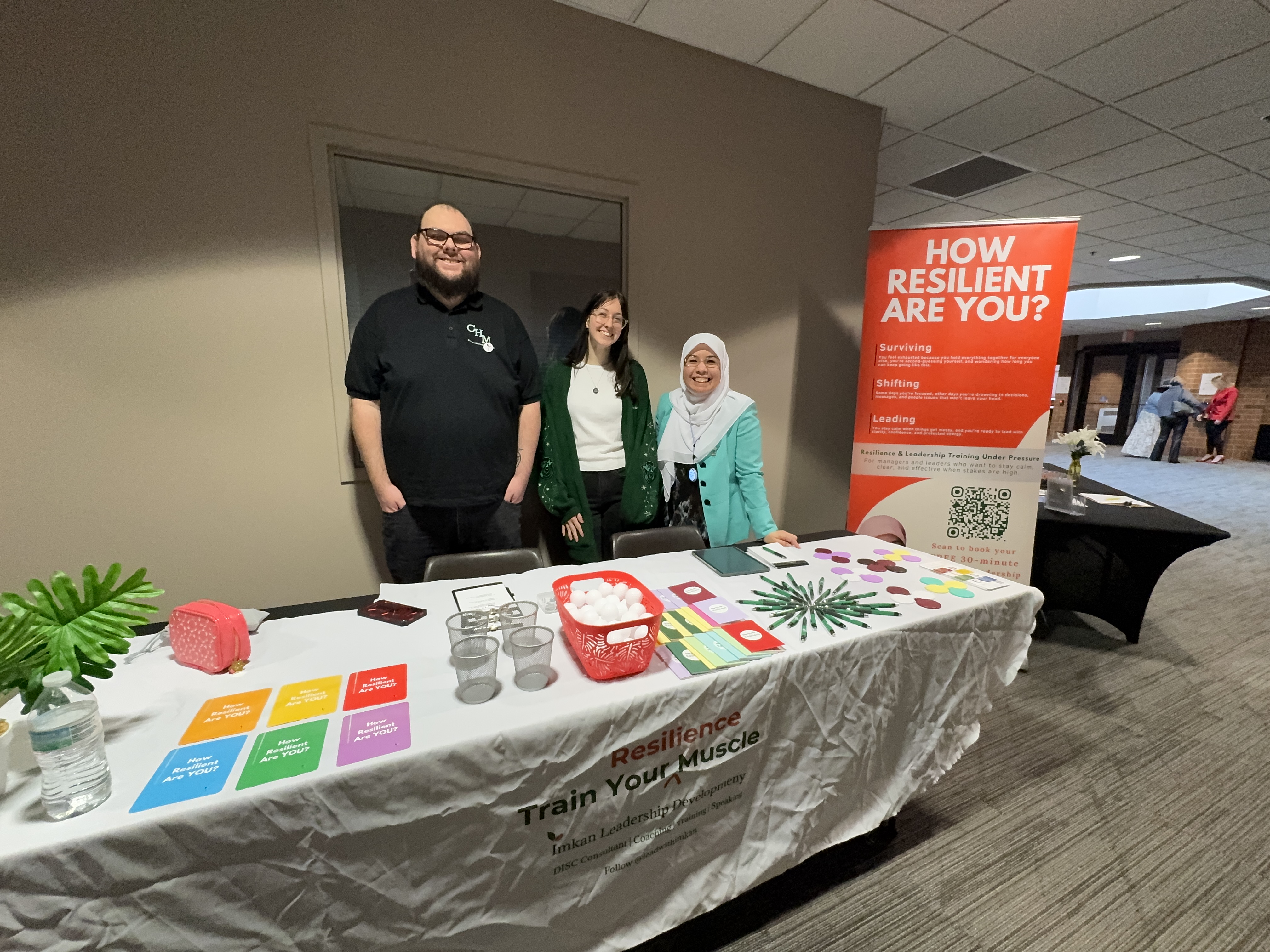 Imkan Leadership Development team at event booth — Chase, Erin, and Nagham Alsamari FemPreneur Summit 2026 Northville, MI