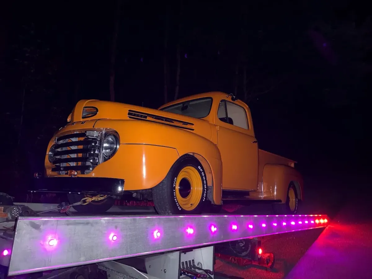 Tow Bro's towing vintage yellow pickup truck at night in Waterbury CT