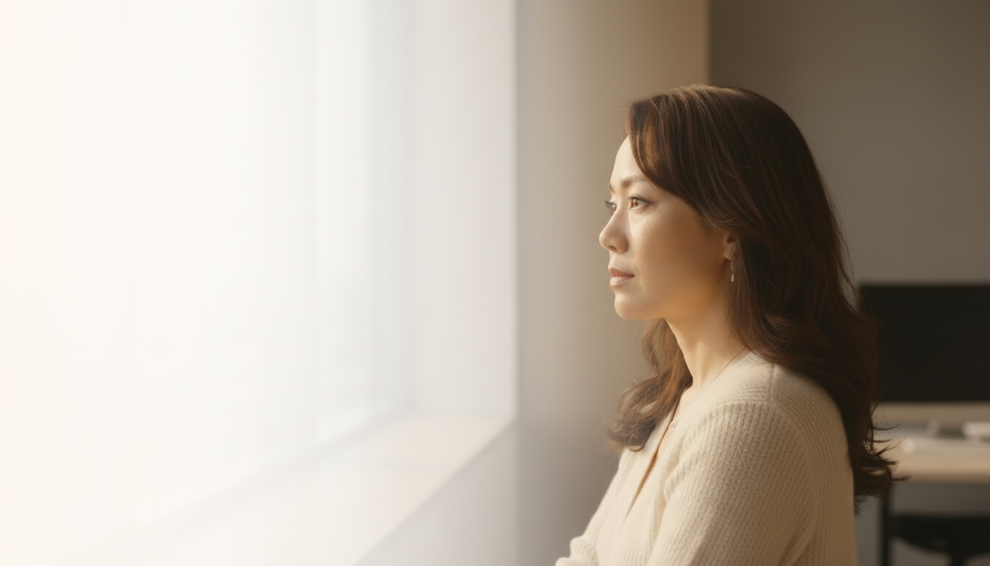 Professional reflecting at window'