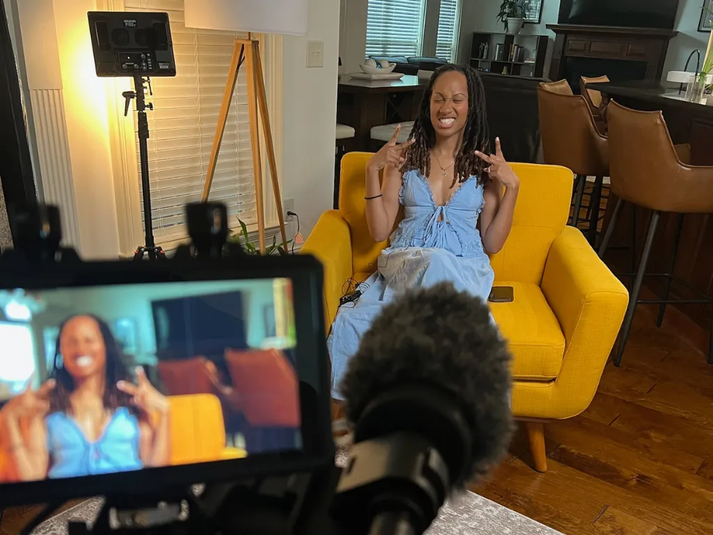 Wedding videographer filming at sunset with handheld camera; cinematic documentary style.