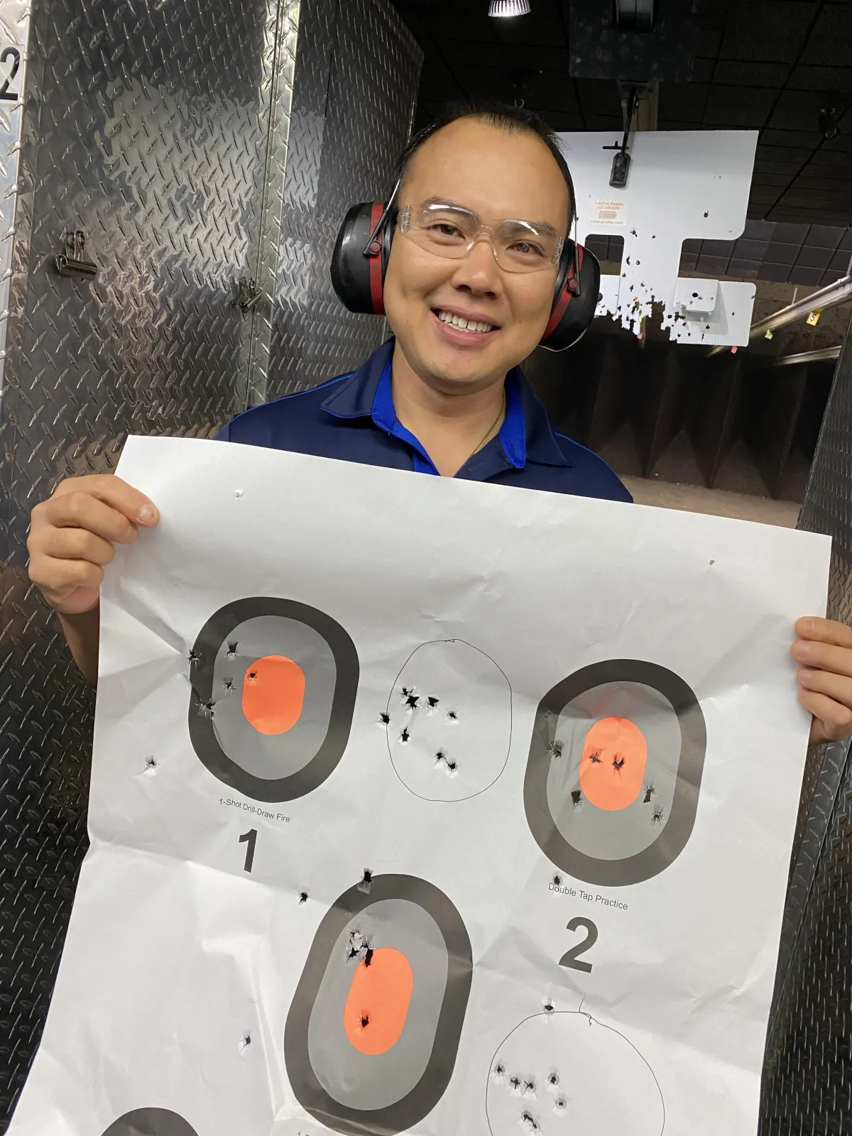 Male student holding target at gun range