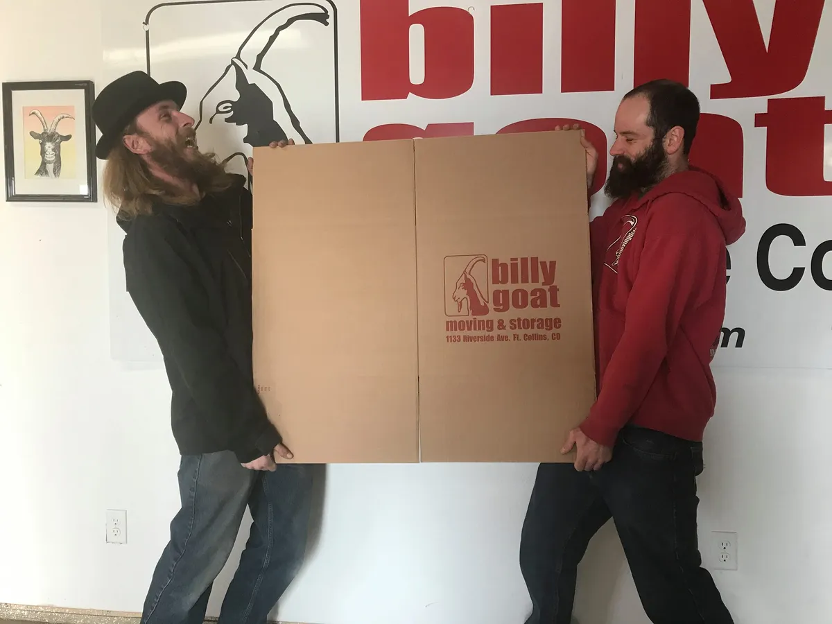Professional residential movers in Fort Collins carrying furniture into a family's new home