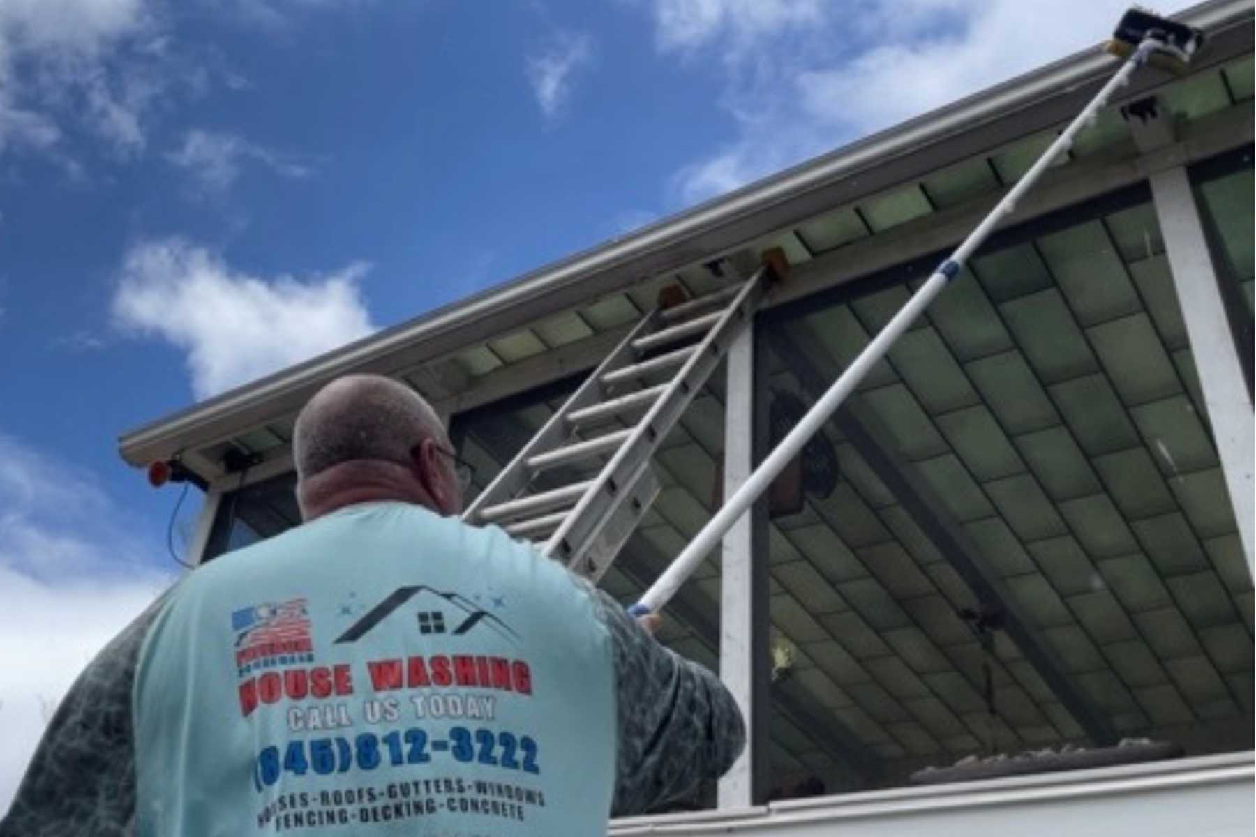 Professional gutter brightening in Woodstock, NY with the Freedom Powerwash owner removing oxidation and restoring the appearance of residential gutters.