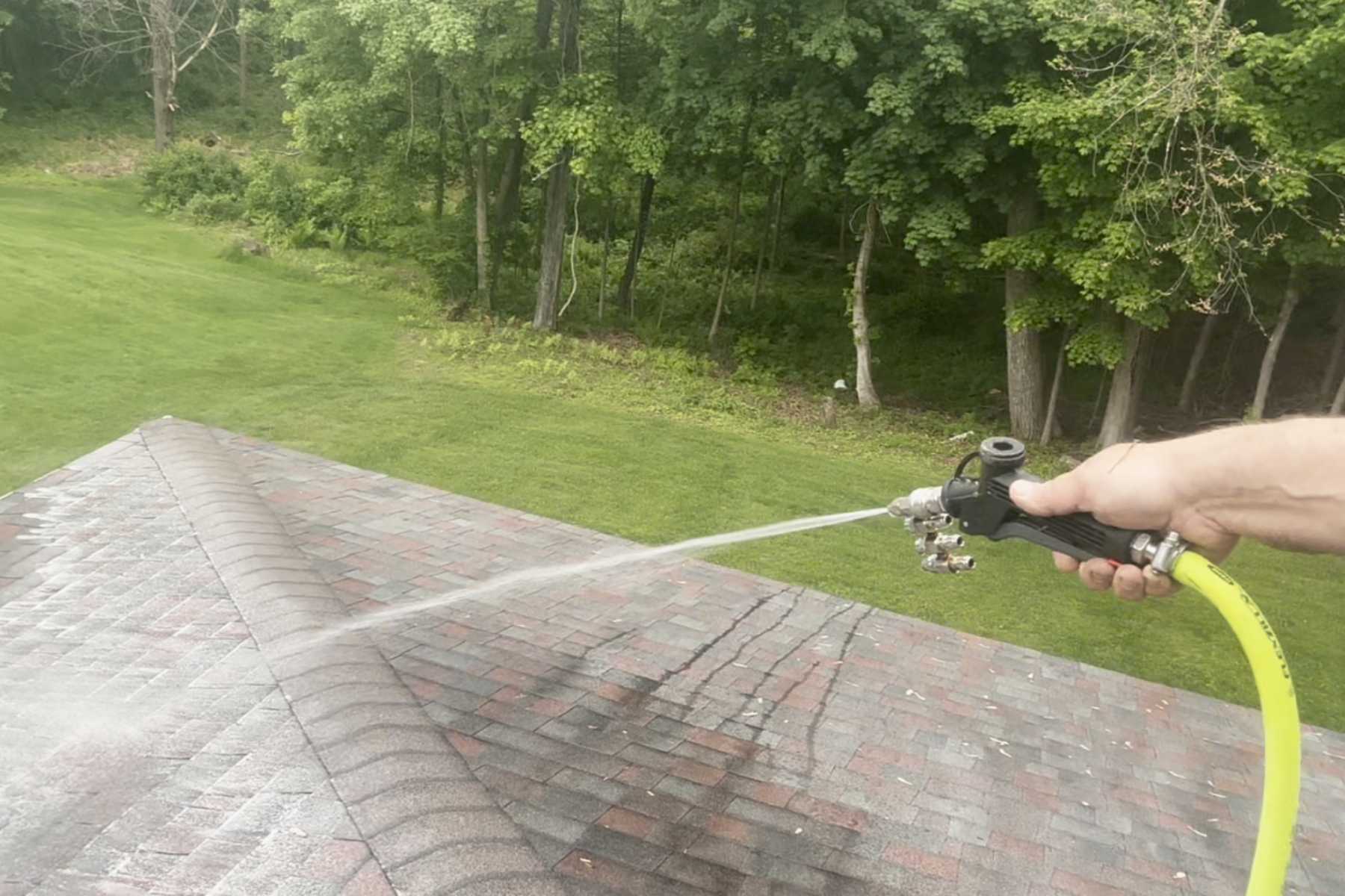 Professional roof soft washing in Stone Ridge, NY with the Freedom Powerwash owner applying a gentle, low-pressure cleaning solution to remove black streaks, algae, and organic growth from asphalt shingles.