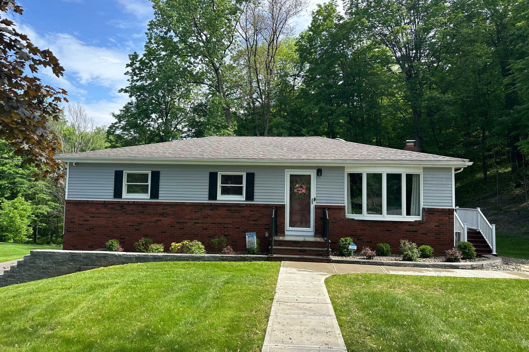 Exterior home cleaning in Kingston, NY with Freedom Powerwash restoring vinyl siding, brick, gutters, and trim using a professional soft-wash process.