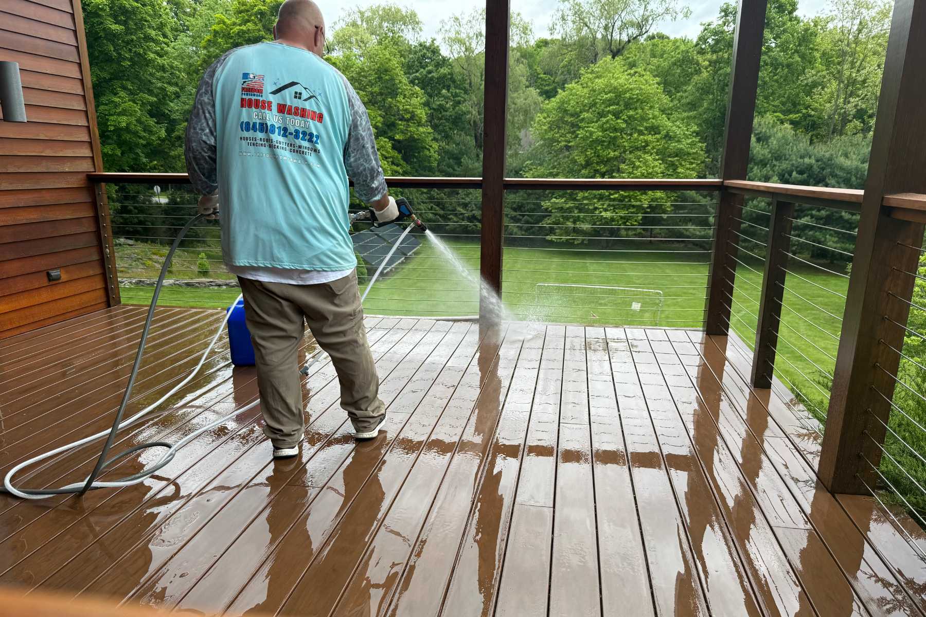Professional deck soft washing in Milan, NY with the Freedom Powerwash owner using a low-pressure soft-wash rinse to clean and restore a composite deck.