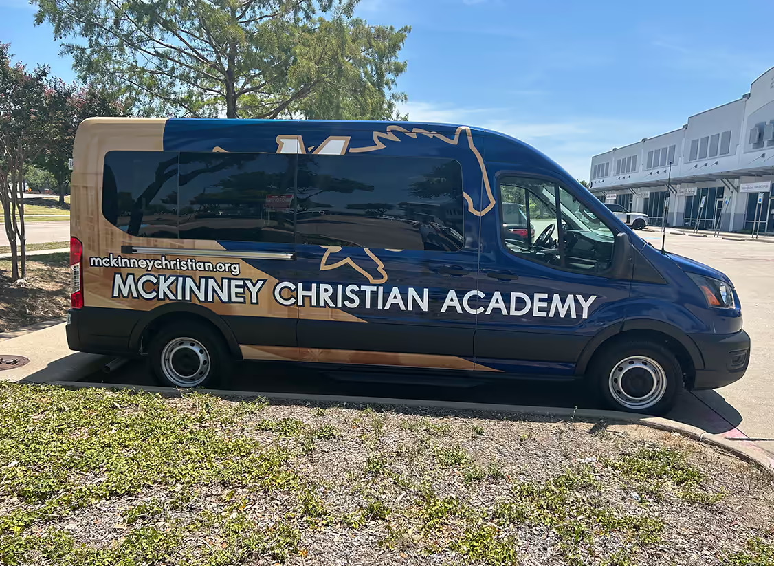 White and blue McKinney Christian Academy wrapped van.
