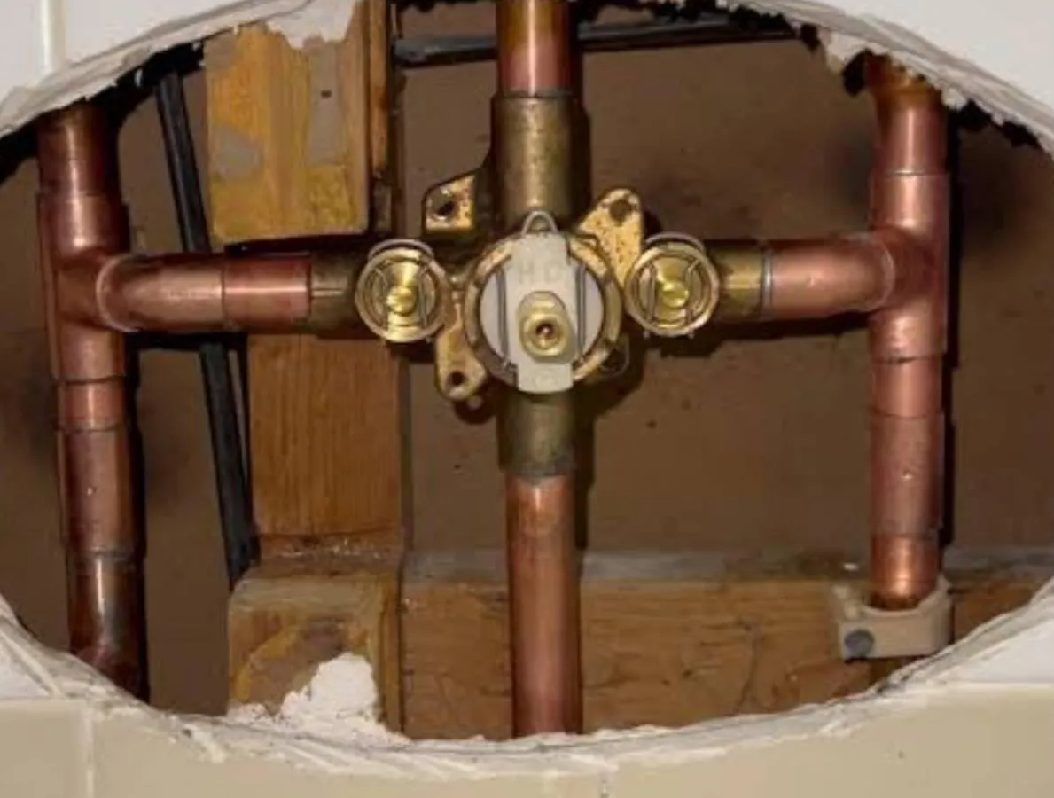Local plumber working on pipes in a San Diego home