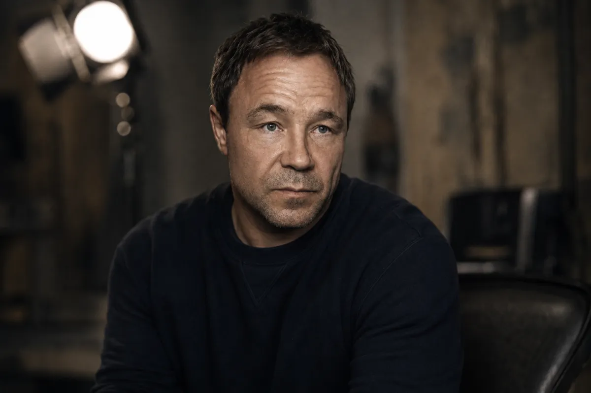 Stephen Graham the actor sitting under soft studio light with a thoughtful expression, reflecting authenticity, emotional depth and the quiet power of British acting.