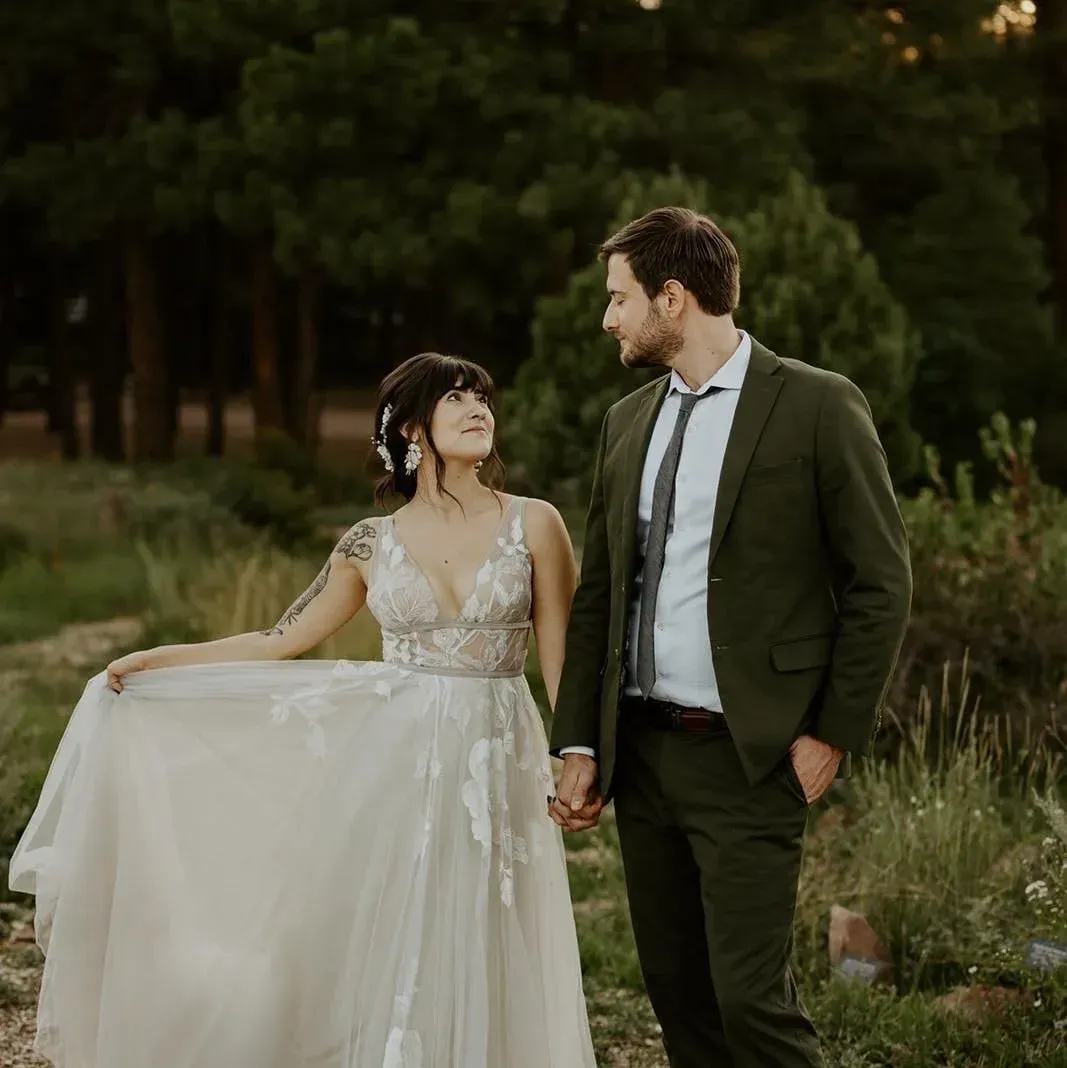 Flagstaff bride in lace wedding gown and groom walking among pine trees, Heartcraft Wedding Films Phoenix wedding videographer, cinematic wedding films