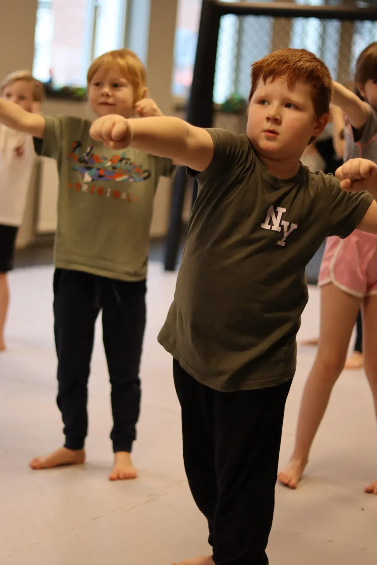 a shirtless man in a gym holding a barbell