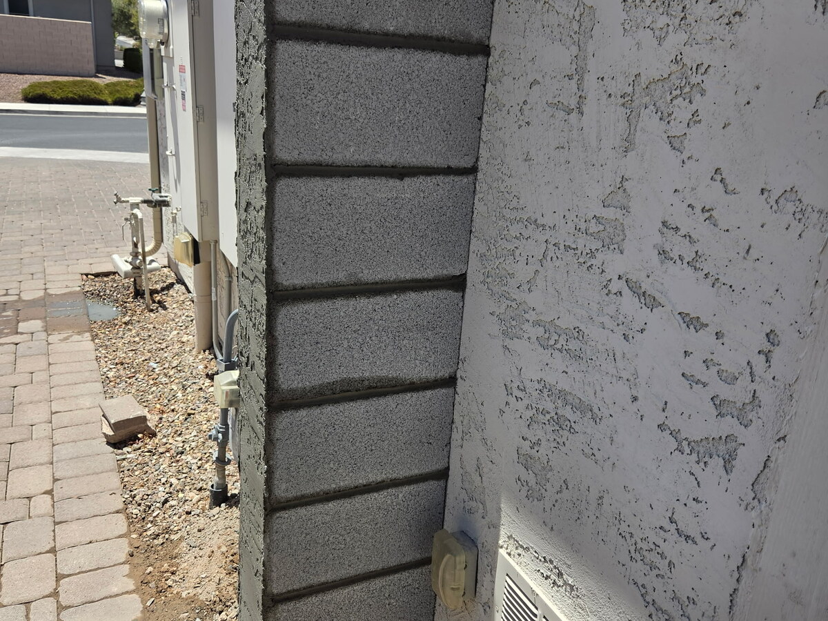 Rebuilt concrete block pillar beside a stucco wall in Phoenix, Arizona